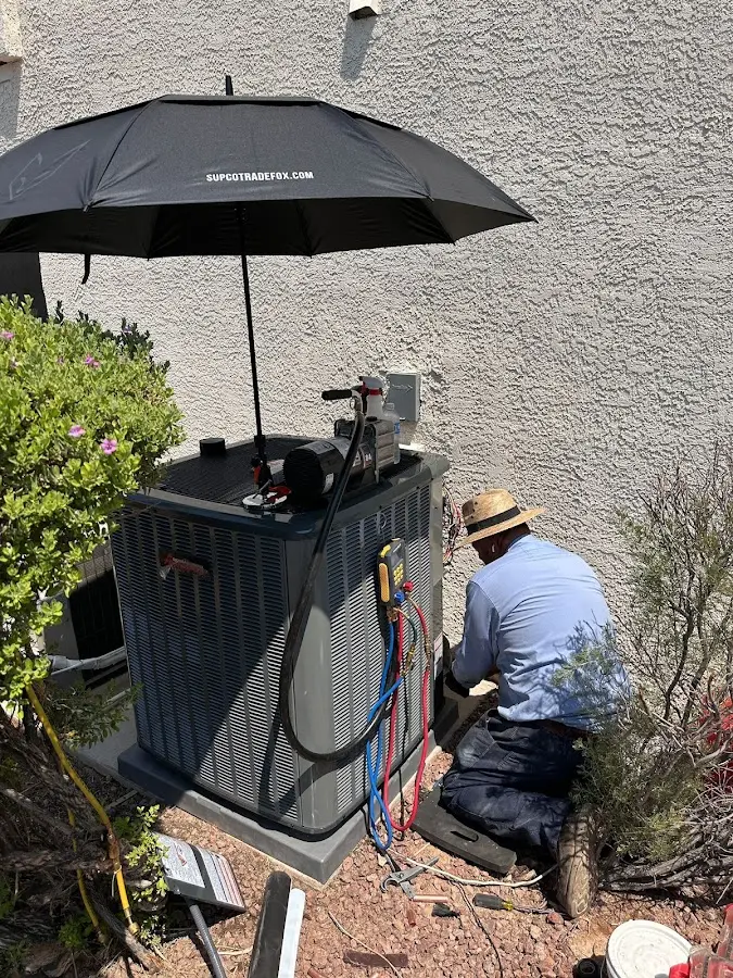 HVAC technician performing outdoor AC maintenance in Exeter