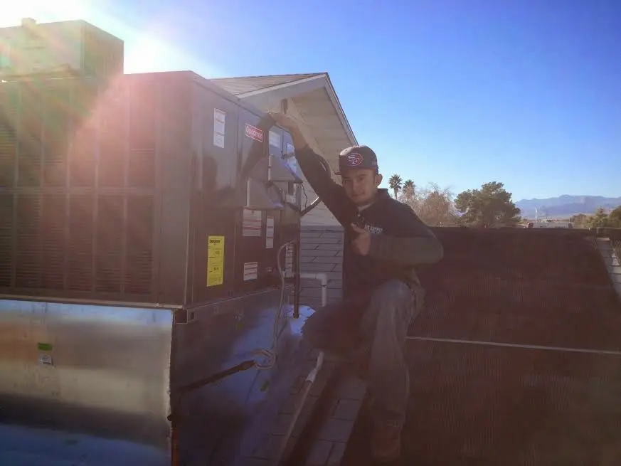 HVAC technician performing Heat Pump Repair on a rooftop unit in Exeter